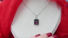 Load image into Gallery viewer, Dainty Thrills sliver necklace with a pendant featuring a red gemstone held by Gillian Magee the Founder with red nail polish.